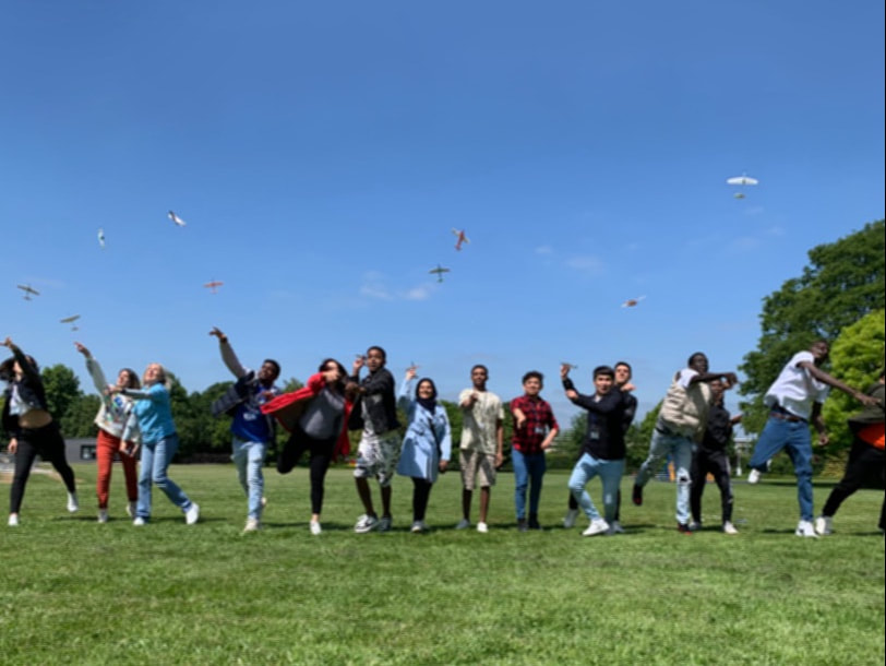 Picture of lots of young people outside flying paper aeroplanes © Big Leaf Foundation